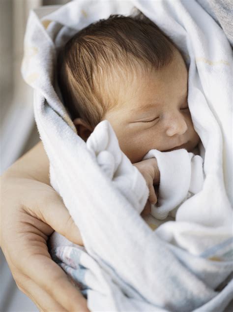 Newborn baby booties in parents hands close up. America's New Mothers Among The Youngest | HuffPost UK