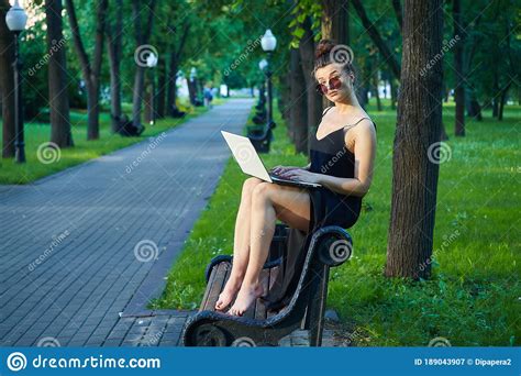 Beautiful Girl Walks Around The City Working On A Laptop Holding A