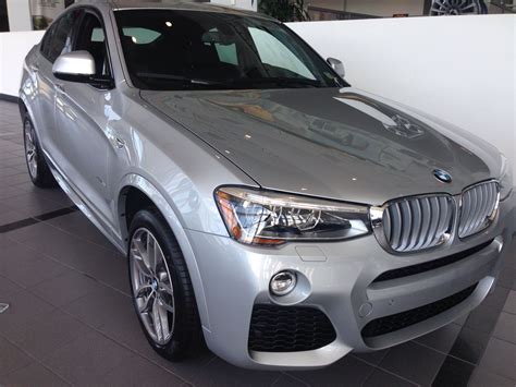 A Silver Bmw Suv Parked In A Showroom