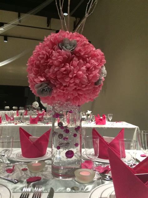 the centerpieces on this table are pink and silver