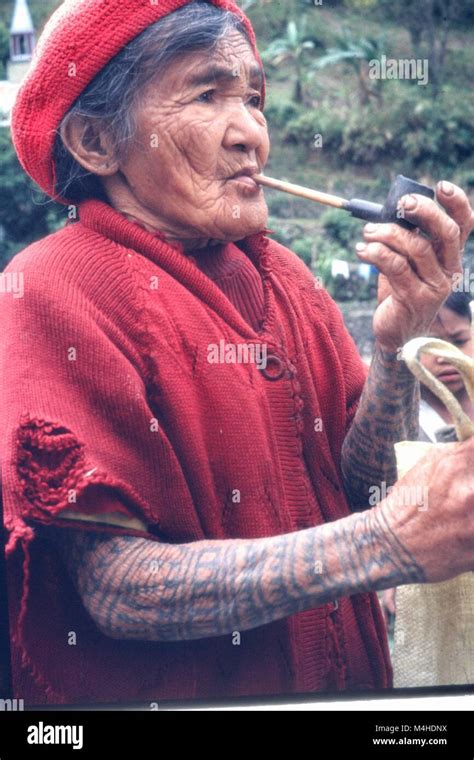 A Tattooed Bontoc Woman With Pipe In A Village In The Valley Of The