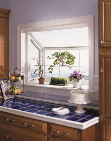 A Kitchen Window With Potted Plants On The Ledge And Blue Tiled Counter