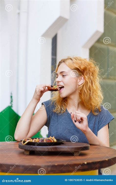 Pretty Happy Woman Eating Juicy Sausages In The Pub Outdoors Stock