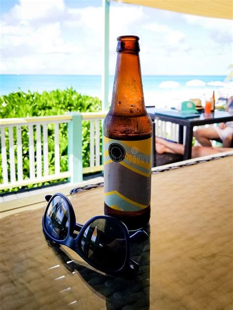 Beer Bottle Next To Sunglasses On Table With Gorgeous View Of B Stock
