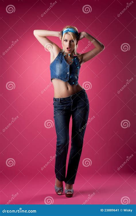 Het Leuke Sexy Meisje Stellen In Jeans Op Roze Achtergrond Stock Afbeelding Image Of