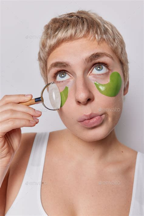 Close Up Shot Of Short Haired Woman Applies Green Hydrogel Patches