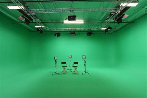 Desk with computer monitor on green screen. green screen stage with chairs setup for interview | Yelp