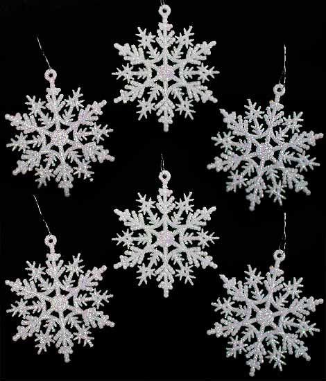 Four Snowflakes Are Hanging From Chains On A Black Background With