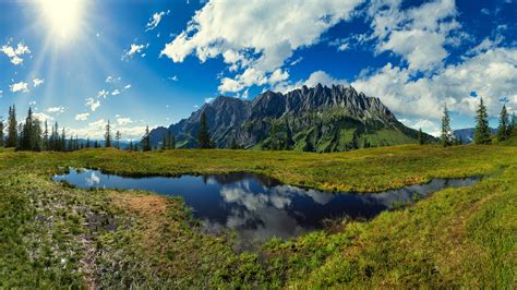 Mountain Under Cloudy Blue Sky With Reflection On Pond With Sunbeam 4k