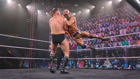 Two Men Wrestling In Front Of An Audience At A Professional Wrestling
