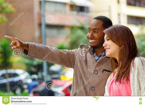 Interracial Happy Charming Couple Wearing Casual Clothes Interacting For Camera In Outdoors