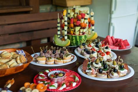 The Buffet At The Reception Assortment Of Canapes On Wooden Board