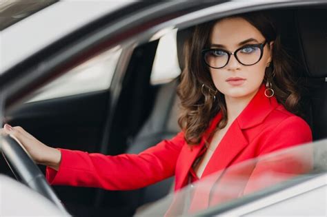 free photo beautiful sexy rich business woman in red suit sitting in white car wearing glasses