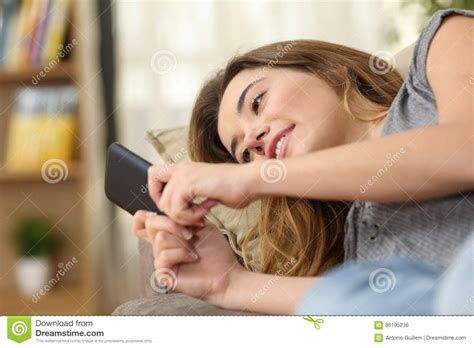 Teen Texting In A Smart Phone Lying On Couch Stock Photo Image Of Background House