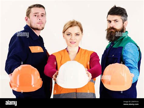 Safety And Protection Concept Men And Woman Wears Uniform And Holds Helmets Or Hard Hats Team