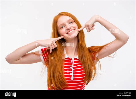 Positive Cheerful Redhead Young Woman Touching Her Cheeks With Fingers Posing On White