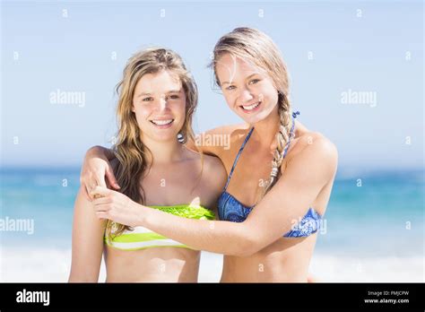 Portrait Of Two Happy Women In Bikini Standing On The Beach Stock Photo