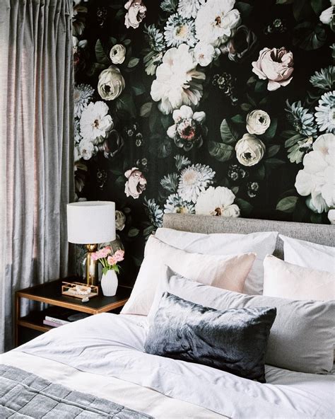 A Bedroom With Floral Wallpaper And White Bedding