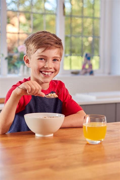 Portrait Of Boy At Home Eating Bowl Of Breakfast Cereal At Kitchen