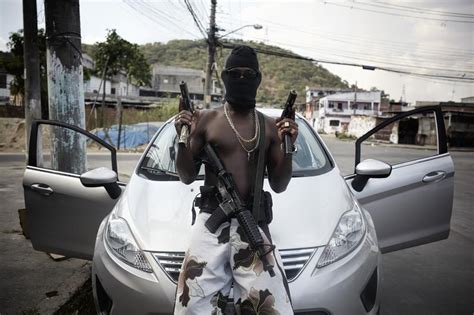 A Gang Member Also Known As A Trafficante Poses With His Weapons In One Of The Many Non