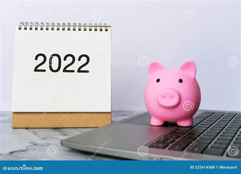 Piggy Bank On Top Of Laptop And Year 2022 Calendar Stock Photo Image