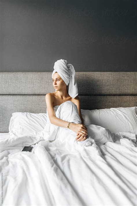 Woman Wrapped In Towel Sitting On Bed By Stocksy Contributor Andrey Pavlov Stocksy