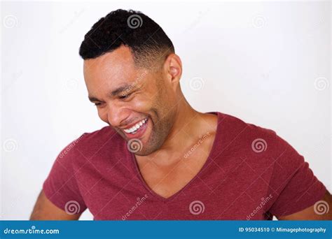 Happy African American Man Looking Down And Smiling Against White