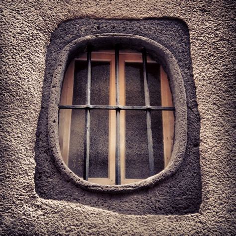 A Window With Bars On The Side Of It