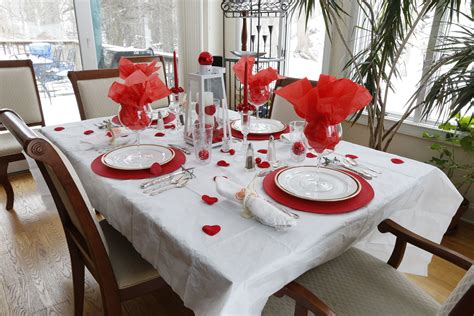 A Dining Room Table Set For Valentines Day With Red And White Plates