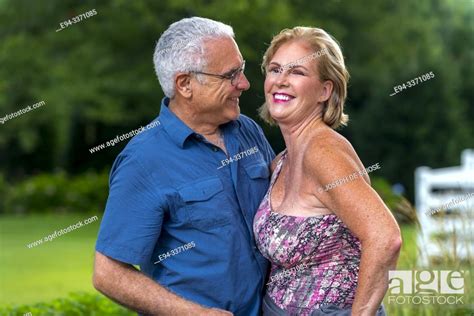 a happy 60 year old blond woman and a 66 year old man laughing and looking at each other