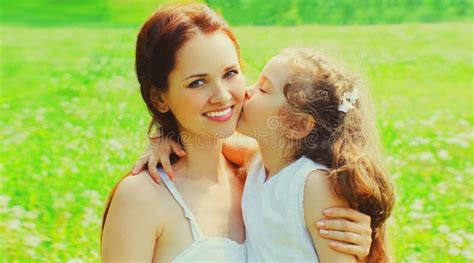 Portrait Of Little Child Daughter Kissing Her Happy Smiling Mother On