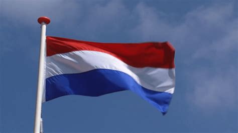 dutch flag in blue sky waving in wind the national flag of the kingdom of the netherlands is a