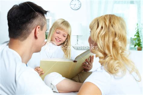 Image Of Parents Listening To Their Daughter While She Reading Book