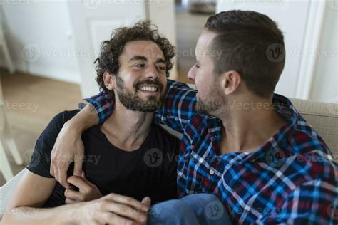 Loving Same Sex Male Gay Couple Lying On Sofa At Home And Relaxing