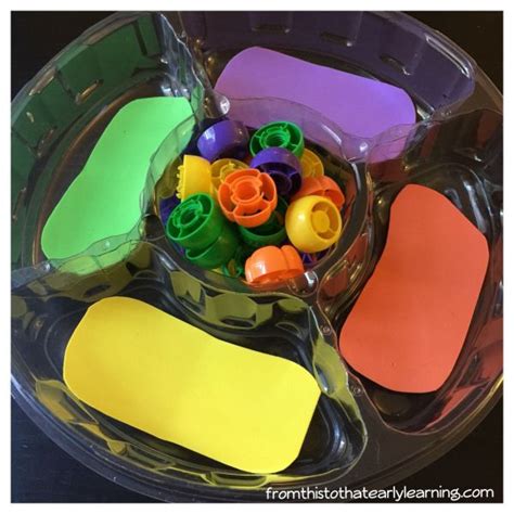 There Are Many Different Colored Crayons In The Plastic Container On