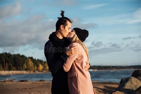 Happy Romantic Couple Kissing On The Beach At Sunset Stock Photo