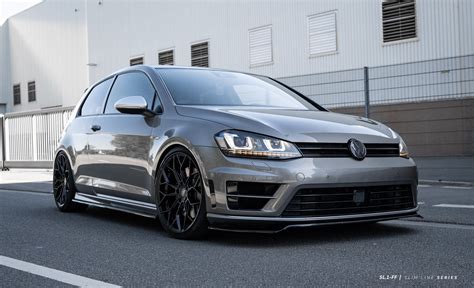 A Silver Volkswagen Golf Gtr Parked In Front Of A White Building With