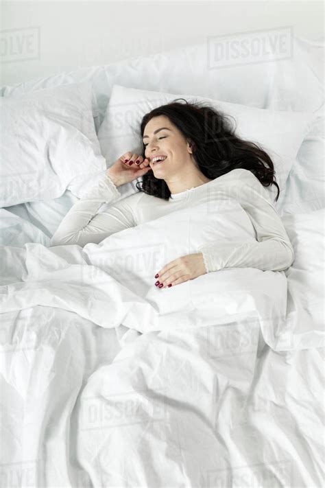 Attractive Woman In White Sleepwear Awakening In Bed At Home Stock