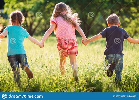 Large Group Of Kids Friends Boys And Girls Running In The Park On