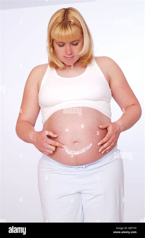 Schwangere Frau Zeichnen Smiley Gesicht Auf Magen Mit Lotion Stockfotografie Alamy