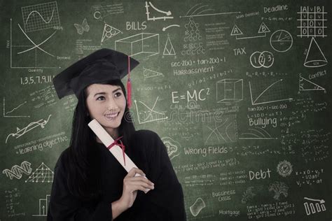 mooie die vrouw in klasse een diploma die wordt behaald die graduatietoga dragen stock foto