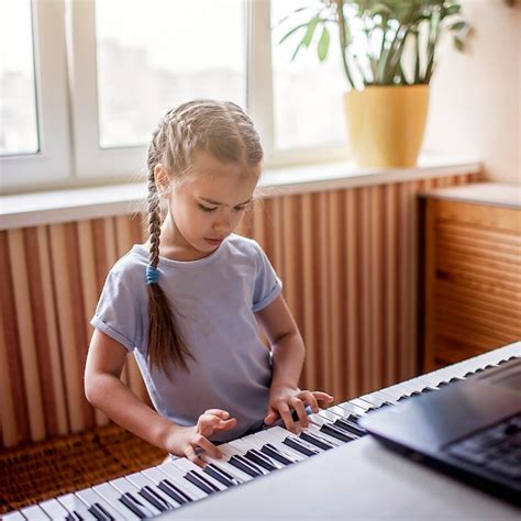 Premium Photo Cute Girl Playing Piano At Home