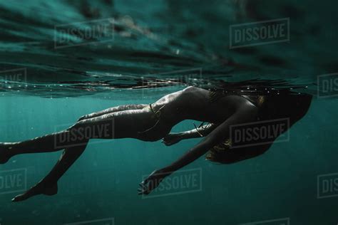 Full Length Dramatic Underwater View Of A Woman In A Bikini Floating Stock Photo Dissolve