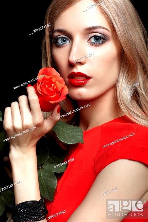 Portrait Of Young Beautiful Blonde Woman In Red Dress With Red Rose In