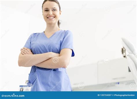 Portrait Of Confident Smiling Nurse With Arms Crossed At Clinic Stock