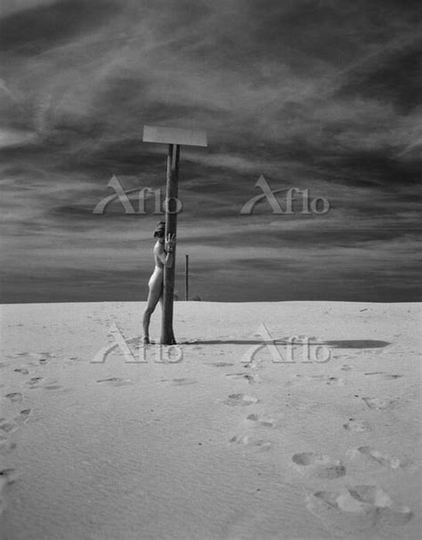 Nude woman standing behind pole on beach b w 7908504 の写真素材 アフロ