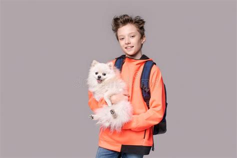 Caucasian Happy Teen Boy Hugging Spitz Dog Guy Is Standing In Sports