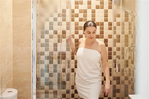 Mature Woman Wrapped In A Towel Stepping Out Of A Shower Stall While