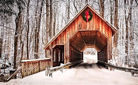 A Covered Bridge In The Middle Of Winter With Snow On The Ground And