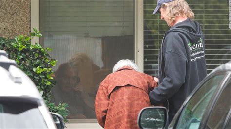 A Touching Photo Shows An Elderly Woman Talking Through A Window To Her